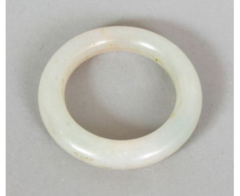 A SMALL CHINESE WHITE JADE BANGLE OR COSTUME RING, possibly 17th/18th Century, the stone of slightly mottled appearance, 1.75