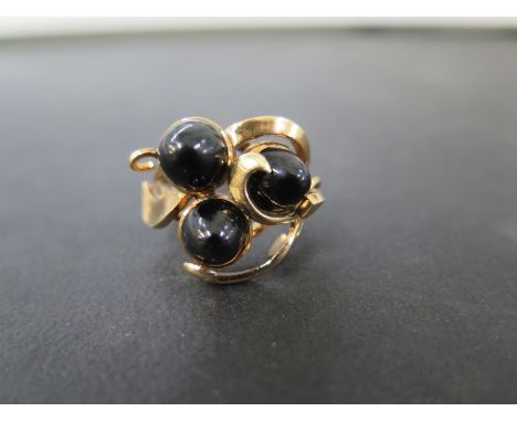 An onyx cabochon three-stone dress ring - With foreign marks and testing as higher carat gold - Ring size Q - Weight approx 7