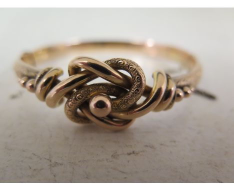 A 9ct gold hinged bangle - With bead and knot detail - Partial hallmark - Inner diameter approx 6cms - Weight approx 11.7gms
