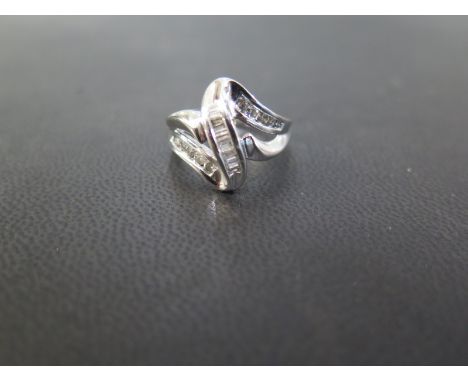 A diamond dress ring - Of abstract design set with baguette and brilliant-cut diamonds - Stamped 10K - Ring size N 1/2 - Weig