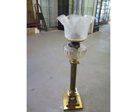 A brass Corinthian column oil lamp with a glass reservoir - Height 87cm - with Hinks burner - some usage marks but generally 