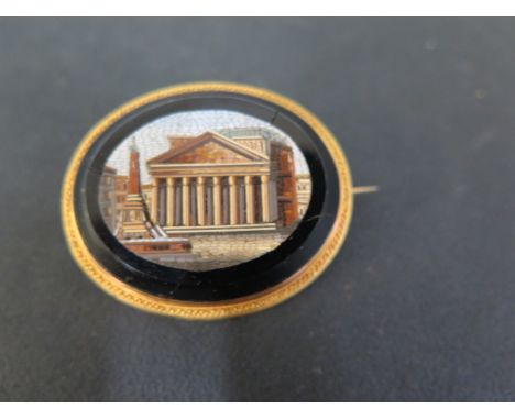 A micro-mosaic brooch - Depicting a Roman building , mounted on black onyx within a decorative surround - With French marks a