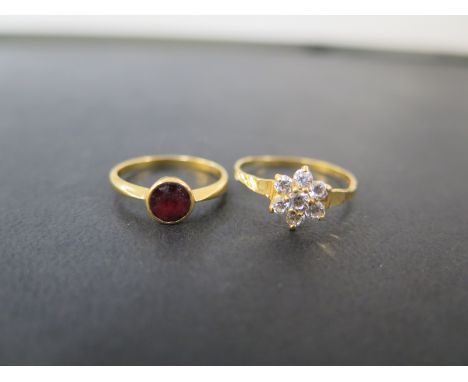 A red-gem single-stone ring - Stamped 22ct - Ring size K - Together with a cubic zirconia cluster ring - Tests as high carat 