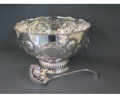 A silver plated punch bowl with wavy rim border, profusely embossed with floral depictions, twin handles on circular foot - H