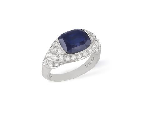 AN 18CT GOLD, SYNTHETIC SAPPHIRE AND DIAMOND RINGCentering a cushion-shaped synthetic sapphire, the tapered step-mount, set w