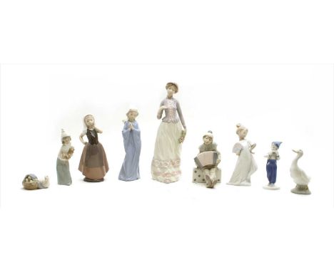 A collection of Lladro, Nao and similar figures, to include boy clown playing concertina on domino, geese, girl with chicken,