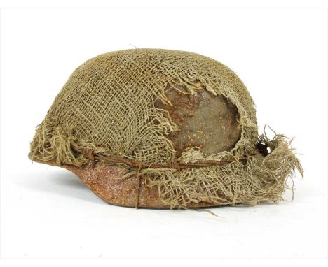 A WWII M35 Normandy hessian covered German infantry combat helmet