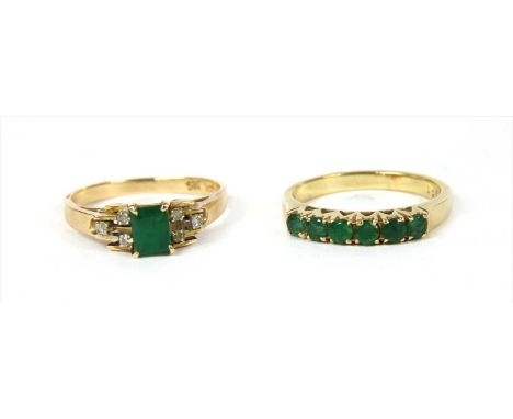 A gold emerald and diamond ring, with a rectangular step cut emerald, claw set with a trefoil of eight cut diamonds, claw set