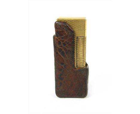 A gold plated Dunhill lighter, with engine turned decoration and leather sleeve