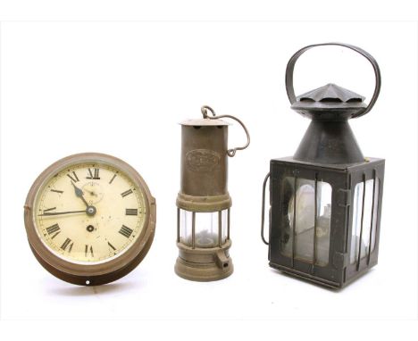 Two lamps and a clock: a miner's lamp by Nunn, a brass ship's clock and a railway lamp