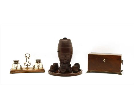 An Edwardian oak and brass inkstand, comprising two inkwells, together with a George III mahogany tea caddy, standing on scro