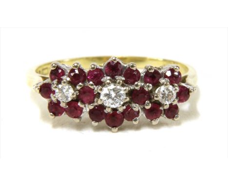 An 18ct gold diamond and ruby triple cluster ring, with a row of graduated brilliant cut diamonds, claw set to surround of ci