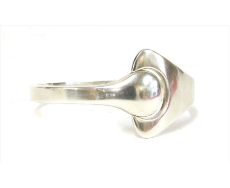 A sterling silver Georg Jensen puzzle bangle, designed by Hans Hansen, polished silver with a puzzle push and release design,