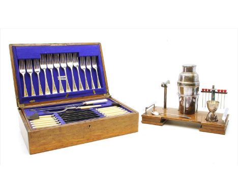 An Art Deco chromium plated and oak cocktail set, on stand, 26cm high, together with two canteens of cutlery, a Reed and Bart
