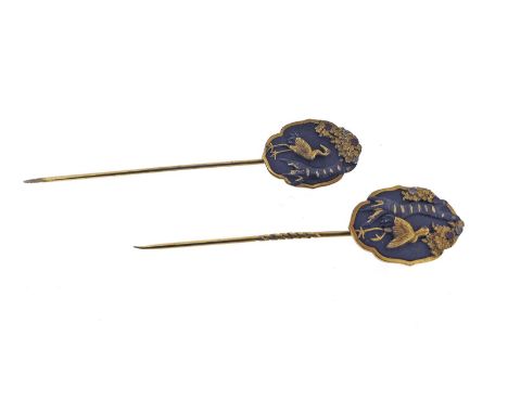 A pair of shakudo-mounted gold stick pins, each plaque depicting a standing crane with foliate, each 2.5cm high