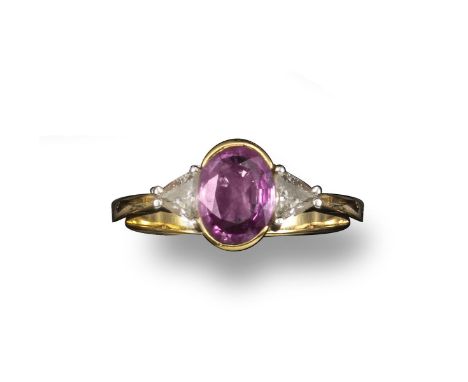 A pink sapphire and diamond ring, the oval-shaped sapphire set with two triangular shoulder diamonds in yellow gold, size R