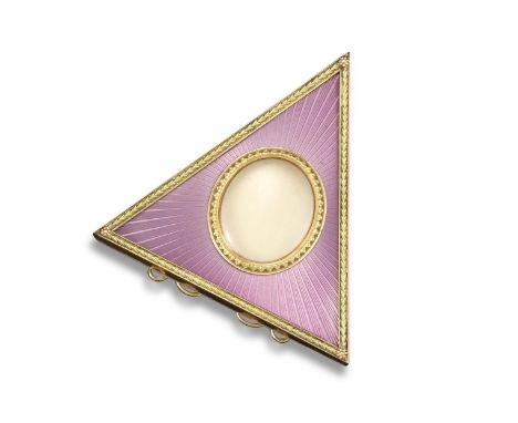 A gold and enamel triangular frame in the Russian style, centred with a glazed oval compartment within a scroll border on mat