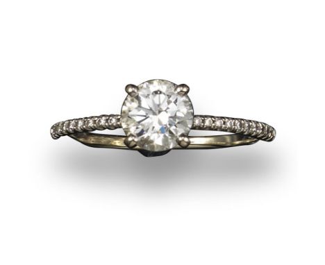 A diamond solitaire ring, the round brilliant-cut diamond weighs approximately 0.90cts and is claw-set with diamond shoulders