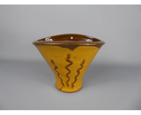 A Winchcombe Pottery Earthenware yellow and brown-decorated glazed oval wall vase, unidentified, approx 14 cms high.