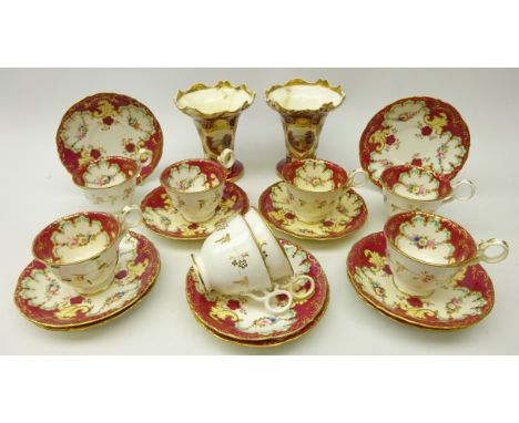 Set of eight early 19th century porcelain tea cups and saucers, hand painted with floral sprays within gilded scroll borders 