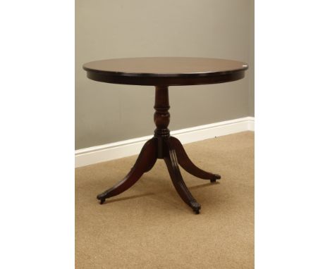 Reproduction mahogany circular tilt top table, turned column with four out splayed legs, claw cups and castors, D91cm, H75cm