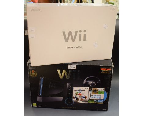 A Nintendo Wii Mario Kart Wii Pack including console, remote, nunchuk, wheel, games, etc
