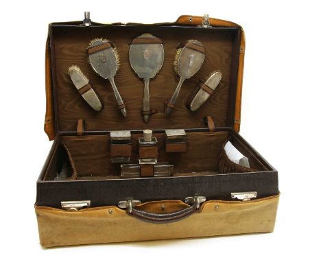 A leather vanity case, 1930's, the interior containing a silver and glass vanity set by Adie Brothers, Birmingham 1935, with 