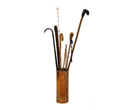 A collection of walking sticks, to include a Bedfordshire Regiment silver mounted swagger stick, a hickory swagger stick with