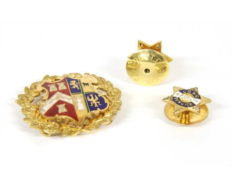 An enamelled coat of arms, the shield with red, white, blue and green guilloché enamel, within a floral and foliate wreath, t