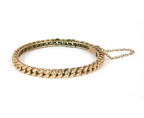 A hinged bangle, with hollow curb chain links on double wire track, to box clasp and safety chain, tested as approximately 9c