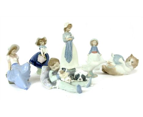 Seven Lladro and Nao figures, including cat and child with puppies, tallest 25cm high