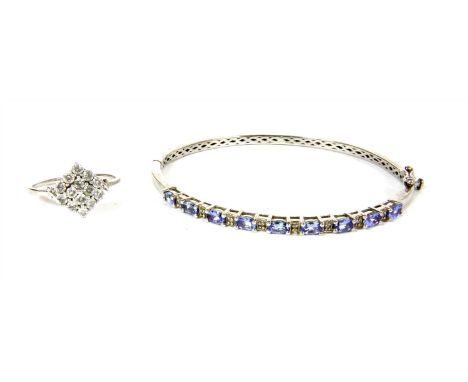 A sterling silver diamond cluster ring, with fourteen round brilliant cut diamonds, claw set to form a rhombus shaped cluster