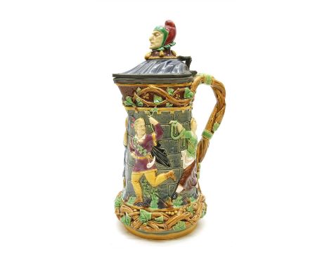 A Minton majolica Jester tower jug, with moulded dancing figures surmounted by pewter hinged shell form lid and jester's head