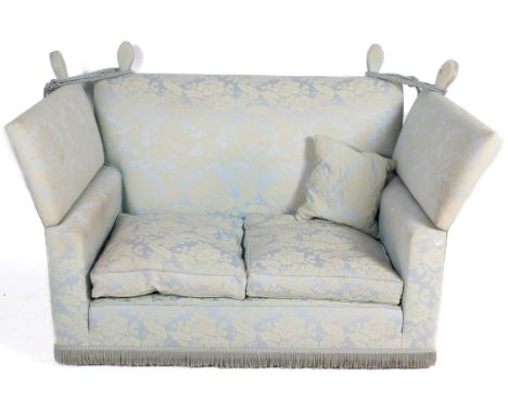 A blue and white upholstered drop end sofa. Having floral design complete with ties and tassels, H95cm x W165cm x D90cm.