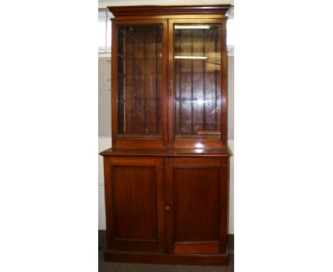 A mahogany glazed bookcase. Two doors open to four shelves, a pair of door beneath open to a single shelf. H 218cm W 106cm.