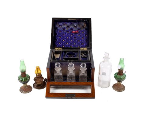 A drop front Victorian mahogany jewellery box with assorted glass bottles and miniature oil lamps. The box fitted with button