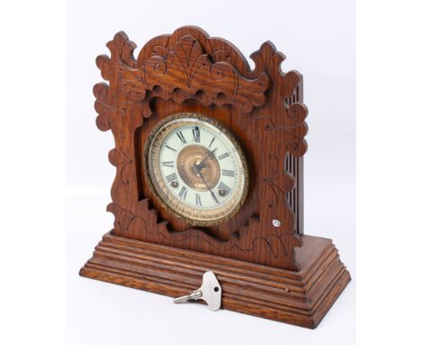 An Ansonia Penton, USA eight day strike oak cased mantel clock. Mechanism striking to a gong, white enamel dial, Roman numera