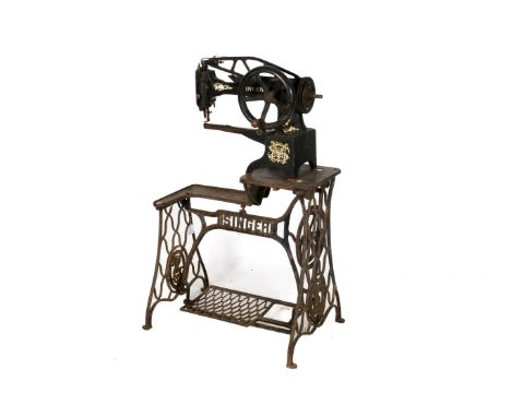 A vintage industrial Singer leather stitching sewing machine and stand. Model Y1648482, having a gilt makers mark, crank hand