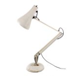 An Anglepoise cream coloured desk lamp. On a circular base.