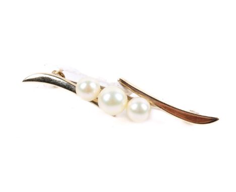 A hallmarked 9ct gold bar brooch by Mikimoto. Set with three cultured akoya pearls graduating in diameter from circa 5.4mm to
