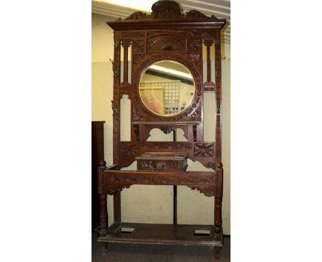 A circa 1900 carved oak hall stand. Carved with floral motifs with brass coat hooks. Bevelled edge mirror to centre, single d