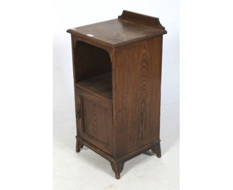 A Victorian oak pot cupboard. Having a shaped gallery and moulded edges, the open shelf over a single panelled door, raised o