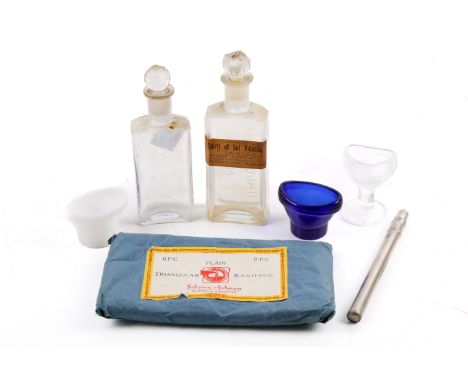 A small group of vintage medical equipment. Including three eye washers, two medicine bottles, cased thermometer, and a pack 