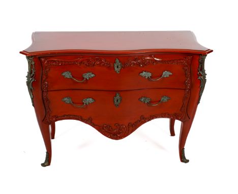 A French style ormolu mounted serpentine commode labelled 'And So To Bed, London'.  Painted red with two drawers. Scrolled fo
