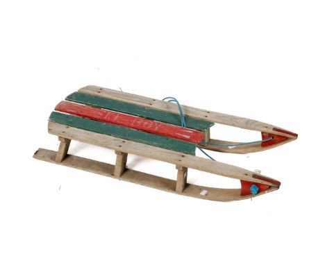 A scratch built vintage wooden sled. With red and green painted seat and metal skids, L89cm.