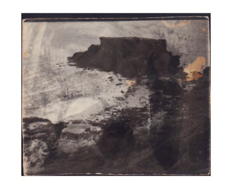 Silver gelatin photograph depicting the rocky shores of Kagman Point and the Square Island. Description printed on back reads