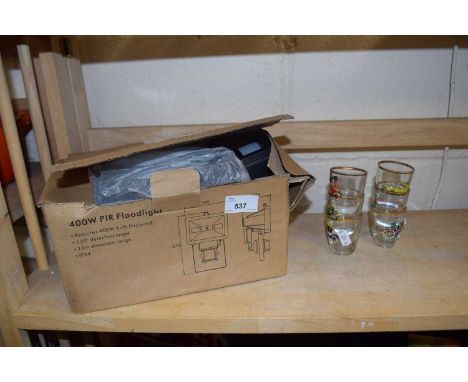 Boxed security light and a quantity of small shot glasses decorated with cars