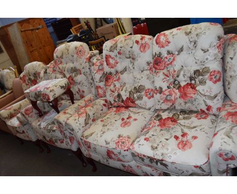 A floral upholstered three piece suite comprising two seater sofa, and armchair and a smaller wing back chair with matching f