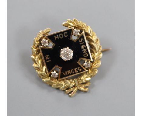 An early 20th century yellow metal, black enamel and diamond set brooch, inscribed in latin 'In this sign thou shalt conquer'