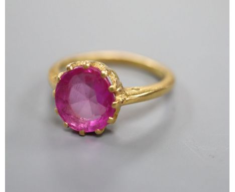 A yellow metal and synthetic? ruby set dress ring, size K/L, gross 4.5 grams.